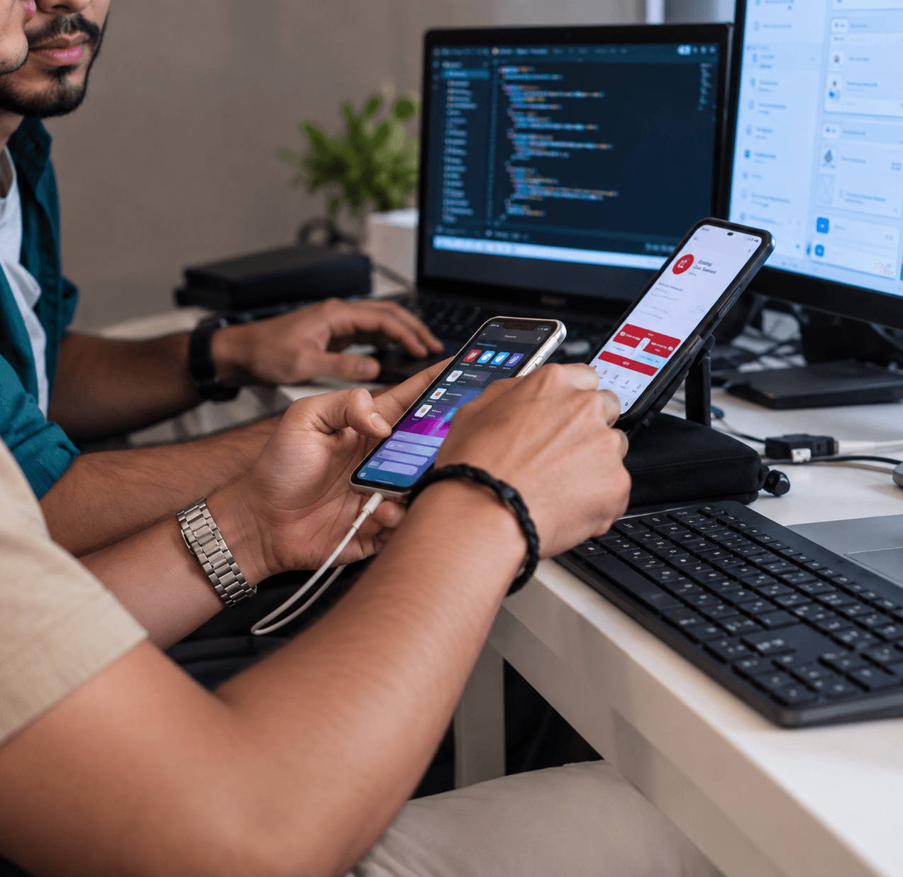 Mobile app developer testing an iOS and Android app on two smartphones side by side